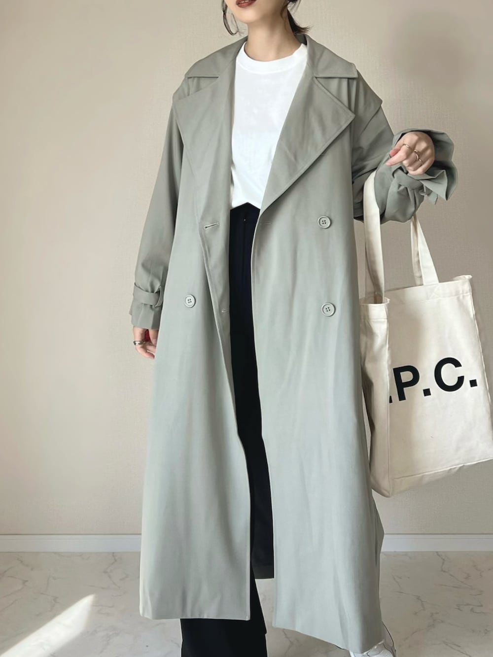 グリーン系のトレンチコート、ホワイト系のTシャツ/カットソー、ベージュ系のスニーカーを着用したレディースの春コーディネートの2枚目の写真