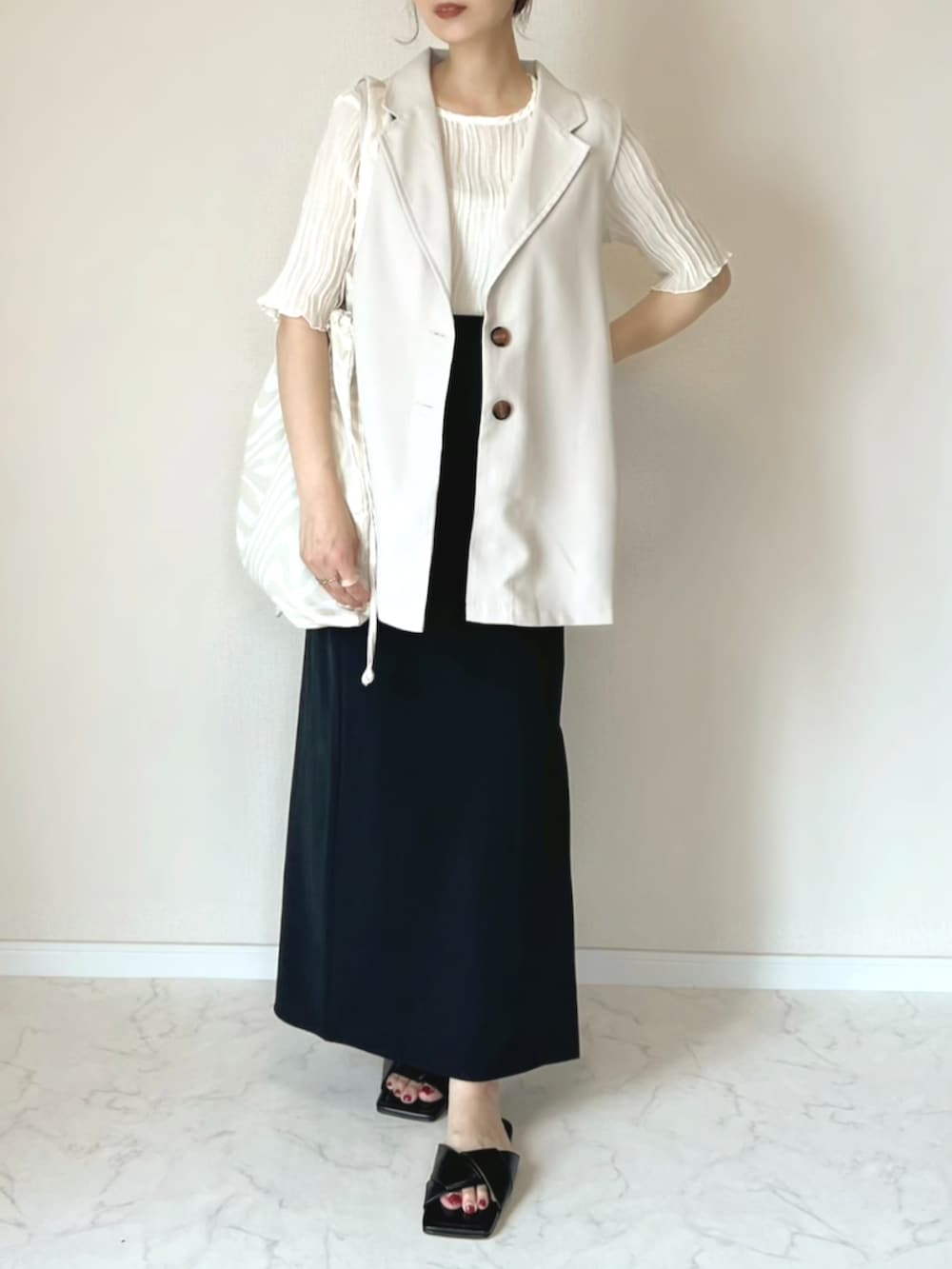 ベージュ系のベスト、ベージュ系のシャツ/ブラウス、ベージュ系のトートバッグを着用したレディースの夏コーディネートの2枚目の写真