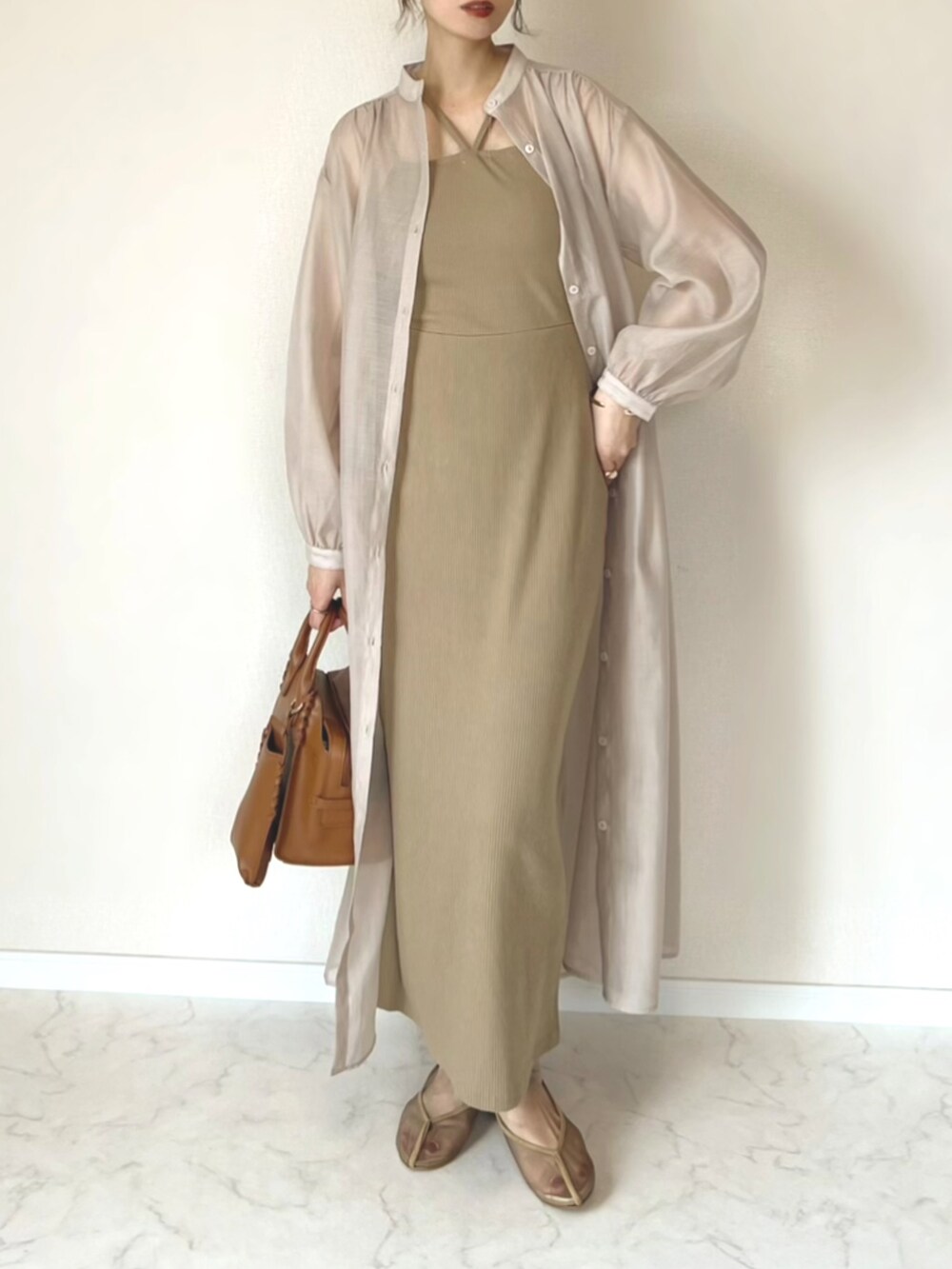 ベージュ系のワンピース、ベージュ系のワンピース、ブラウン系のハンドバッグを着用したレディースの夏コーディネートの2枚目の写真