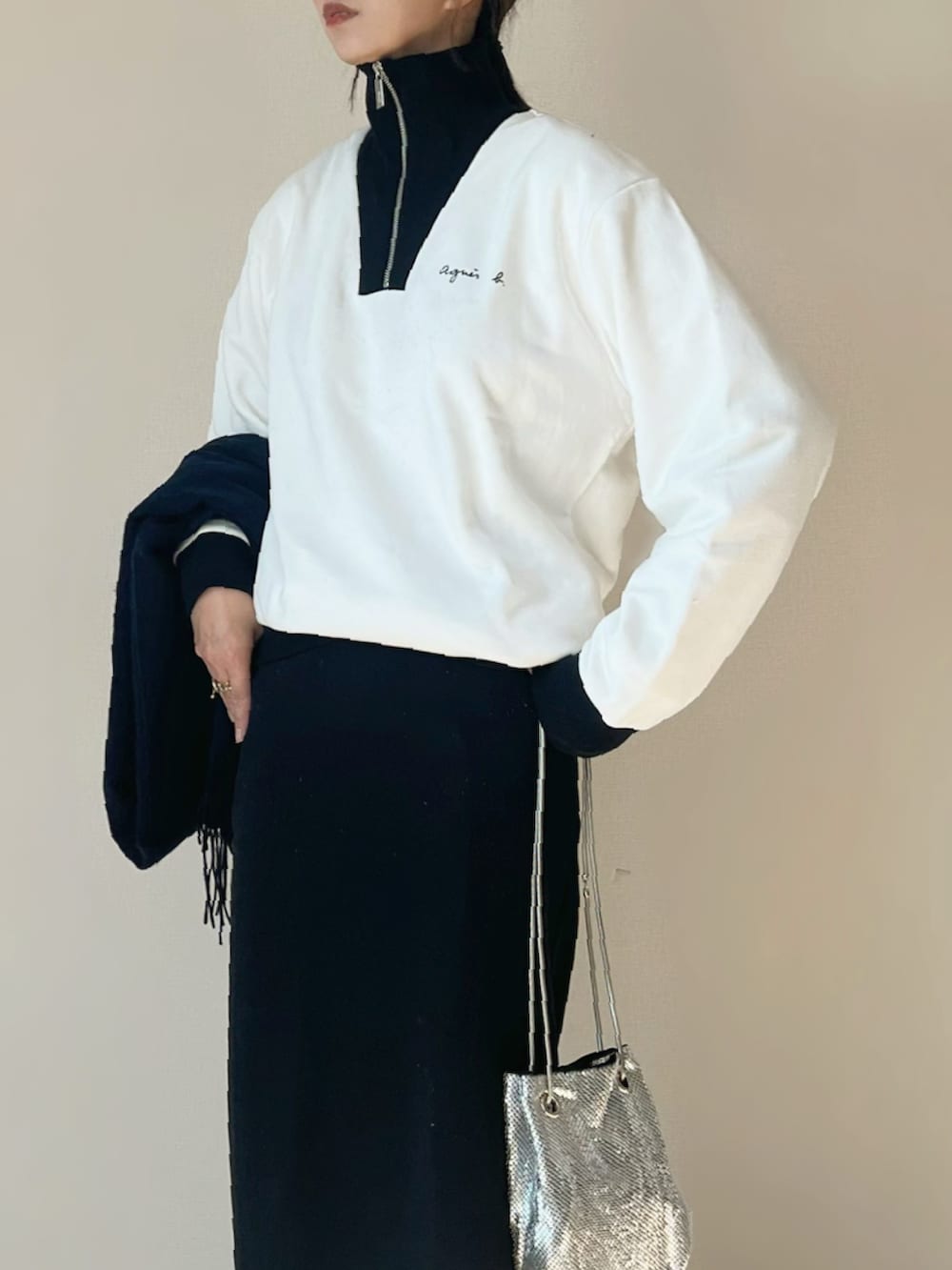 ホワイト系のスウェット、ブラック系のスカート、ホワイト系のスニーカーを着用したレディースの秋コーディネートの2枚目の写真