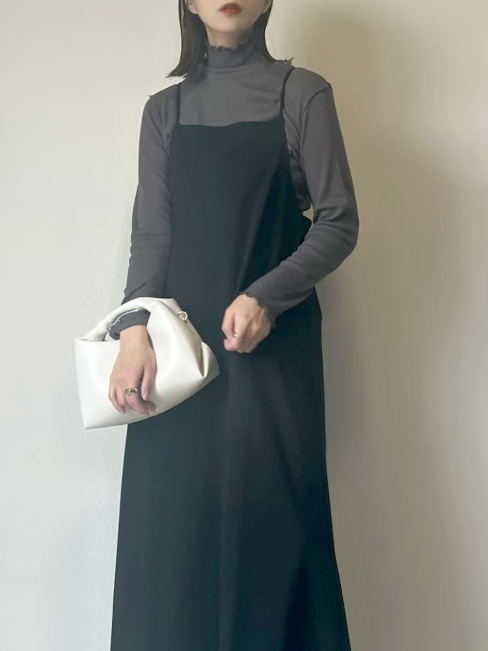 グレー系のTシャツ/カットソー、ブラック系のワンピース、ホワイト系のハンドバッグを着用したレディースの冬コーディネートの2枚目の写真