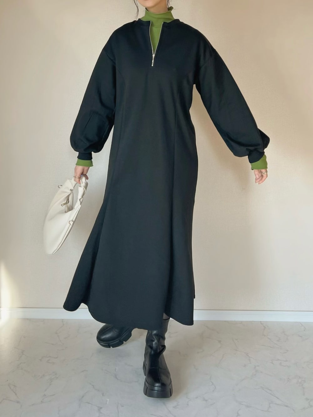 ブラック系のワンピース、グリーン系のTシャツ/カットソー、ホワイト系のショルダーバッグを着用したレディースの冬コーディネートの2枚目の写真