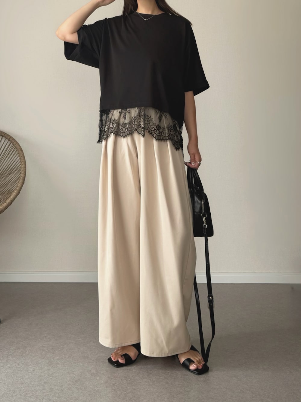 ブラック系のサンダル、ブラック系のTシャツ/カットソー、ホワイト系のスラックスを着用したレディースの夏コーディネートの3枚目の写真