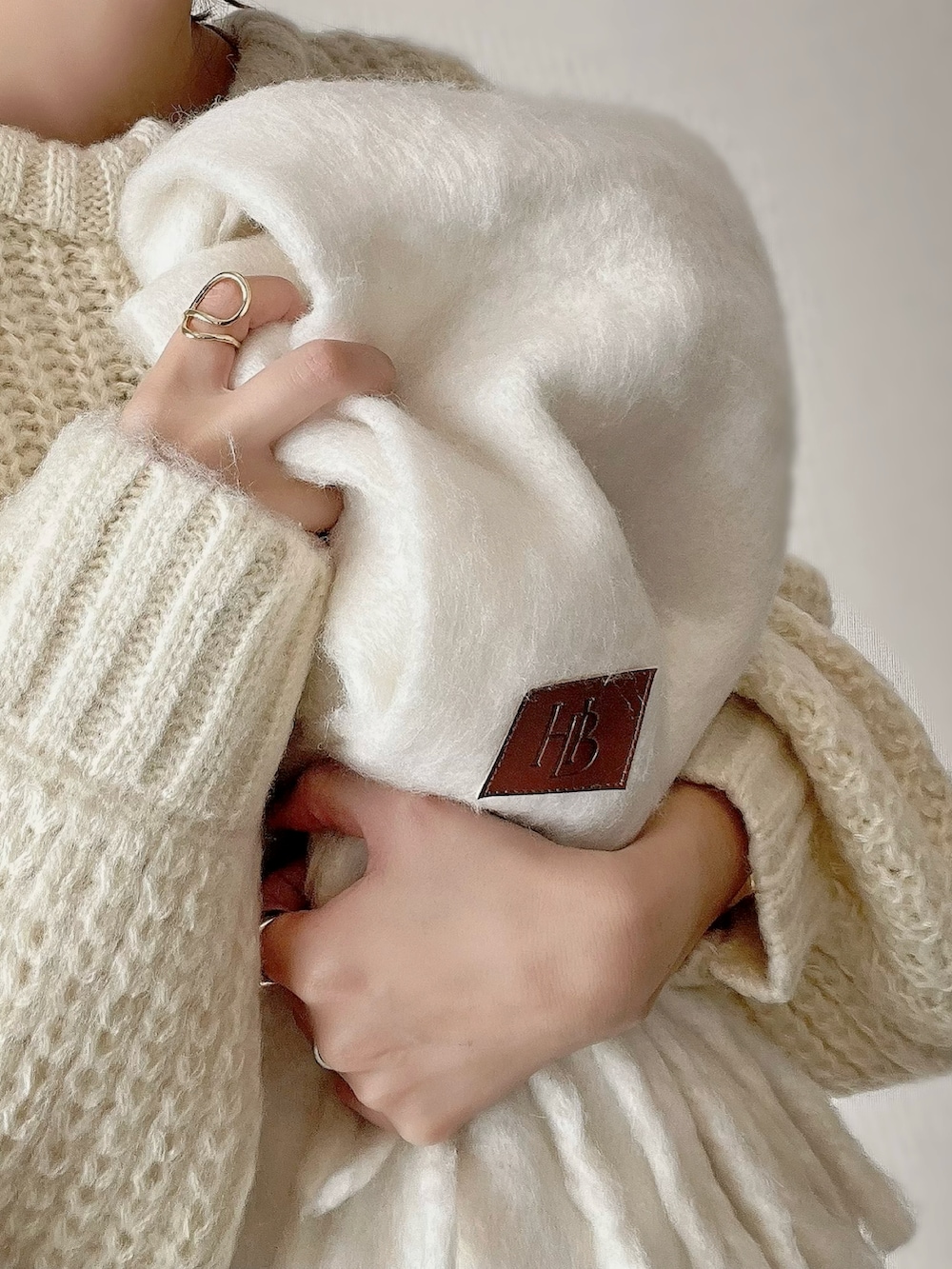 ホワイト系のカーディガン/ボレロ、ブラウン系のパンツ、ブラウン系のブーツを着用したレディースの秋コーディネートの2枚目の写真