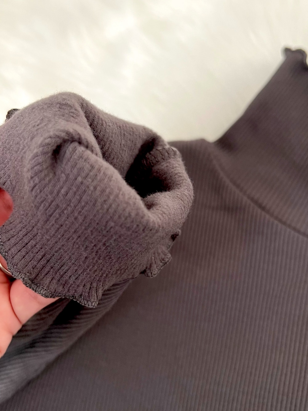 グレー系のTシャツ/カットソー、ブラック系のワンピース、ホワイト系のハンドバッグを着用したレディースの冬コーディネートの4枚目の写真