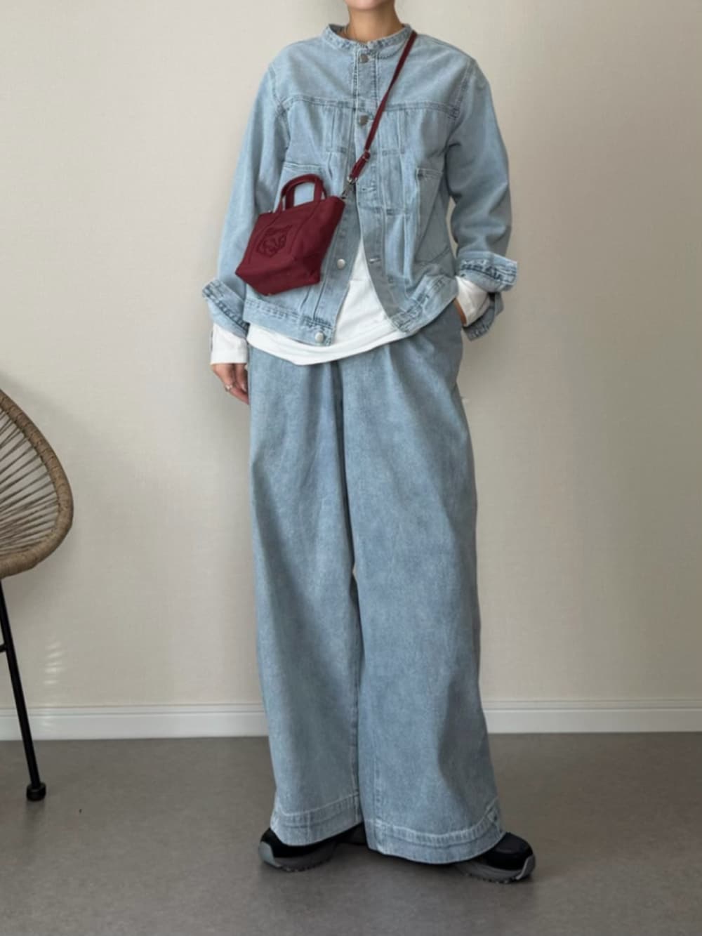 ブルー系のデニムジャケット、ブルー系のその他パンツ、レッド系のトートバッグを着用したレディースの冬コーディネートの2枚目の写真