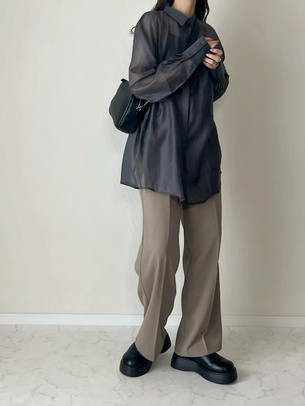 ベージュ系のスラックス、ブラック系のショルダーバッグ、ブラック系のスリッポンを着用したレディースの春コーディネートの4枚目の写真