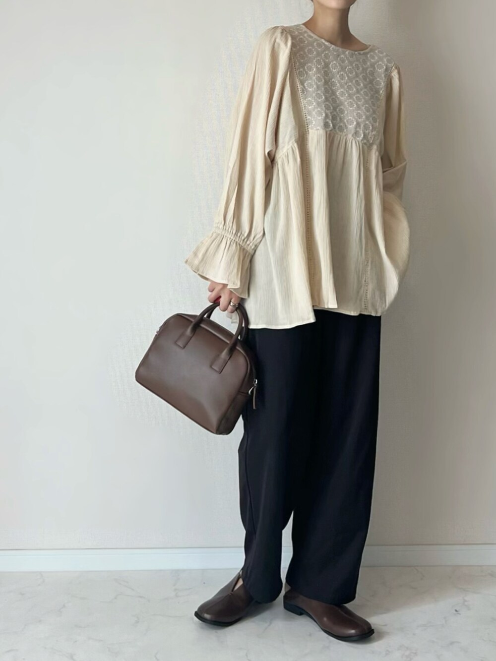 ホワイト系のチュニック、ブラウン系のその他シューズ、ブラウン系のボストンバッグを着用したレディースの秋コーディネートの2枚目の写真