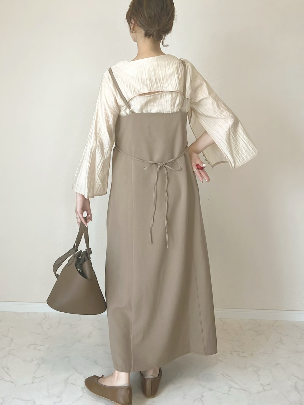 ブラウン系のワンピース、ブラウン系のパンプス、ベージュ系のブレスレットを着用したレディースの春コーディネートの4枚目の写真