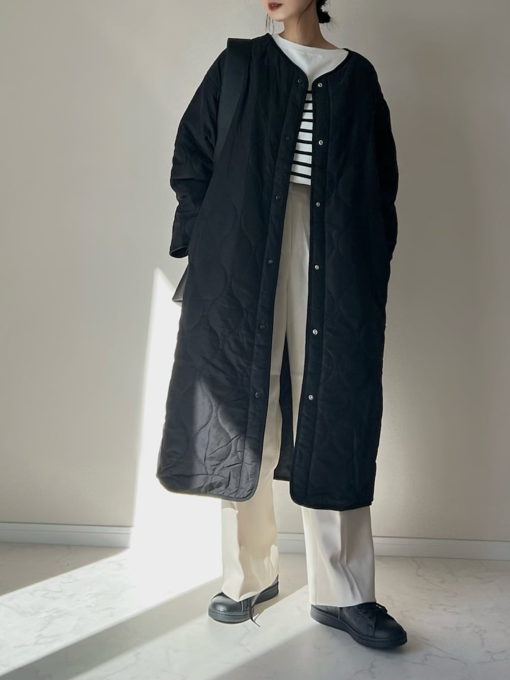 ホワイト系のニット/セーター、ブラック系のノーカラーコート、ブラック系のスニーカーを着用したレディースの秋コーディネートの2枚目の写真