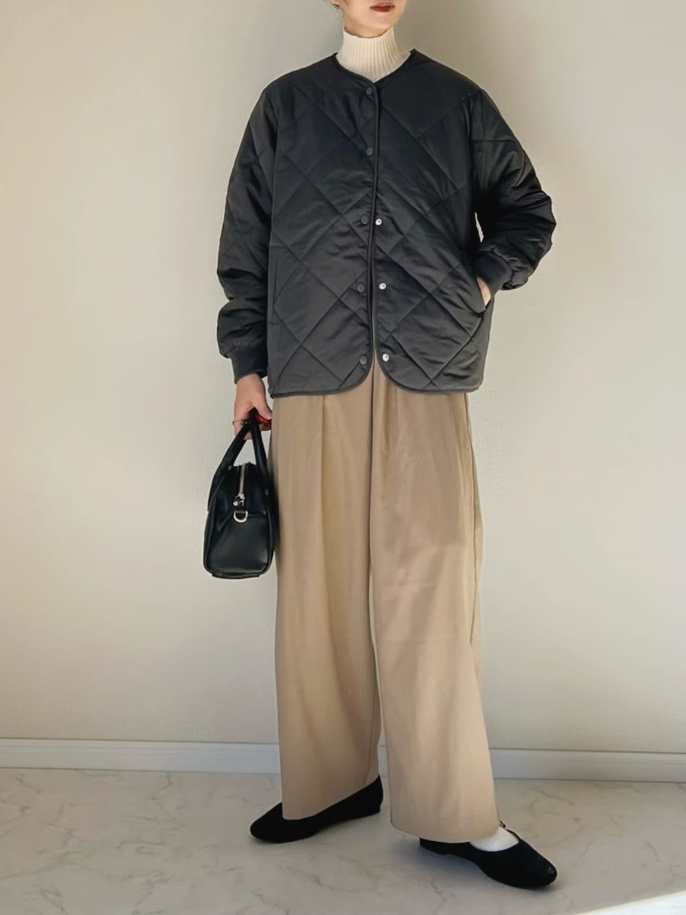 グレー系のダウンジャケット/コート、ホワイト系のニット/セーター、ブラウン系のその他パンツを着用したレディースの秋コーディネートの3枚目の写真