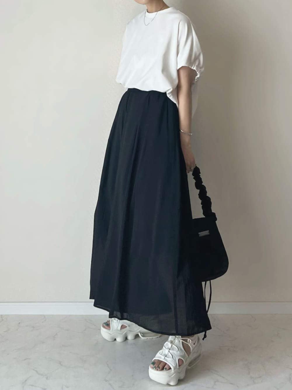 ブラック系のその他パンツ、ホワイト系のTシャツ/カットソー、ベージュ系のサンダルを着用したレディースの夏コーディネートの3枚目の写真