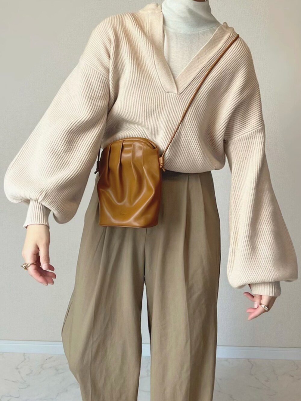 ホワイト系のニット/セーター、イエロー系のショルダーバッグ、ブラウン系のブーツを着用したレディースの秋コーディネートの3枚目の写真