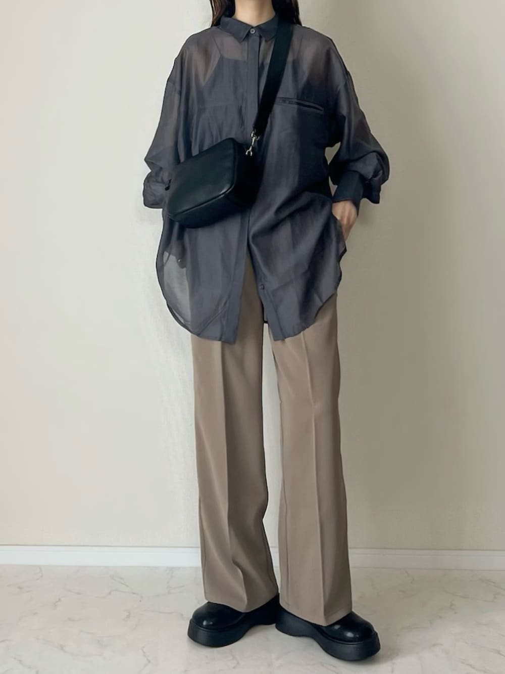 ベージュ系のスラックス、ブラック系のショルダーバッグ、ブラック系のスリッポンを着用したレディースの春コーディネートの3枚目の写真