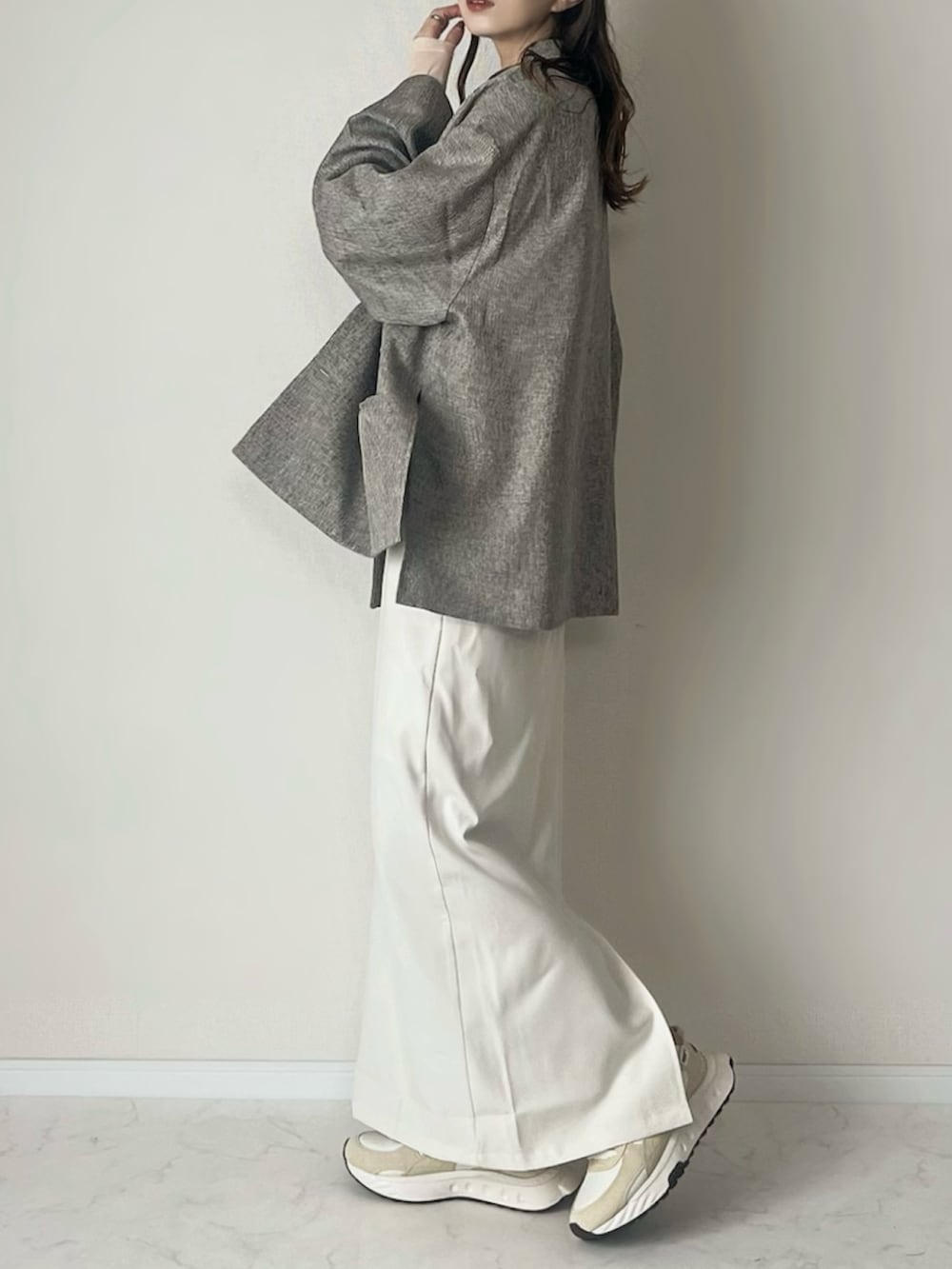 ベージュ系のテーラードジャケット、ホワイト系のスカート、ブラウン系のボストンバッグを着用したレディースの春コーディネートの3枚目の写真