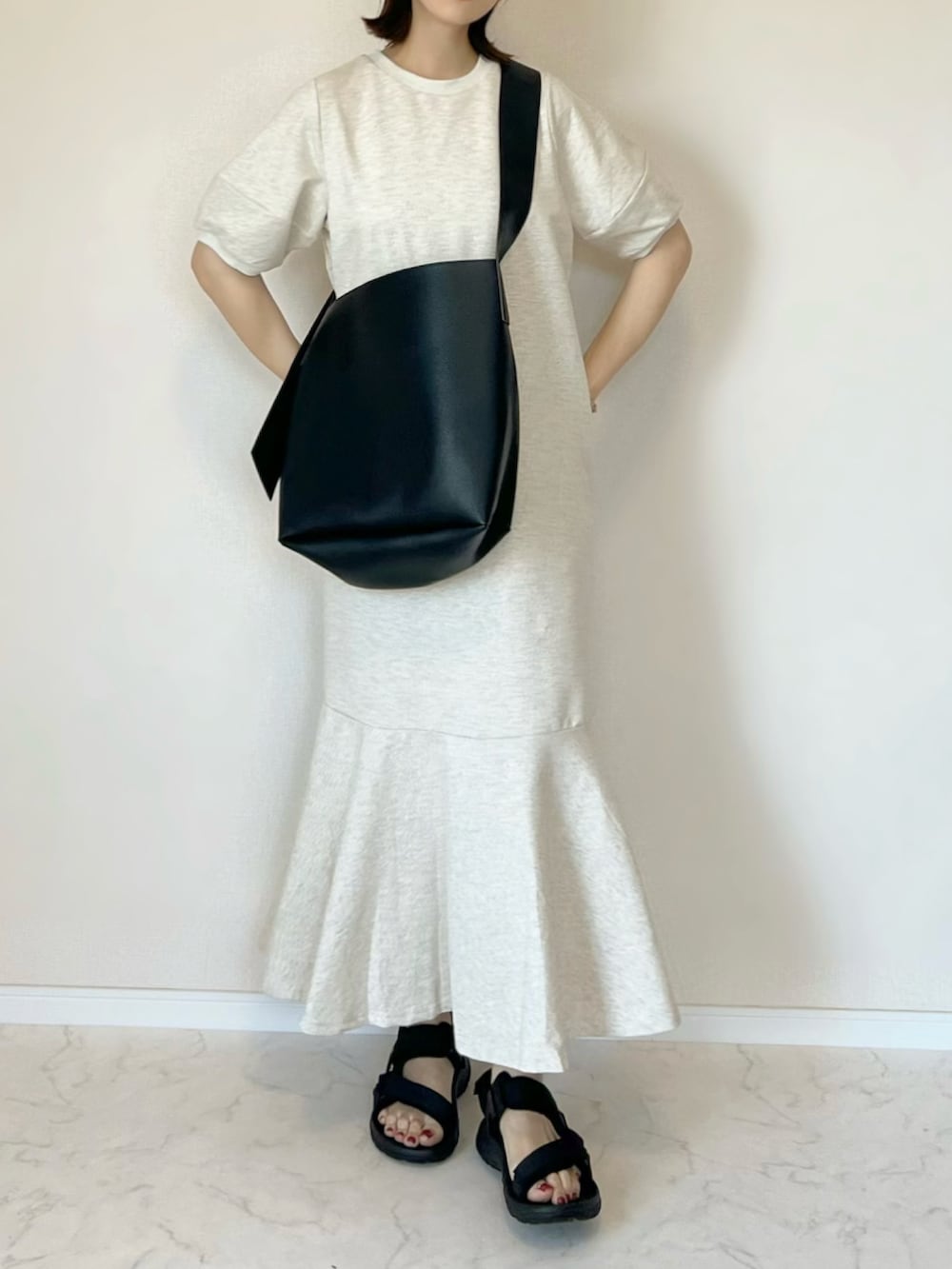 ベージュ系のワンピース、ブラック系のショルダーバッグ、ブラック系のサンダルを着用したレディースの春コーディネートの2枚目の写真