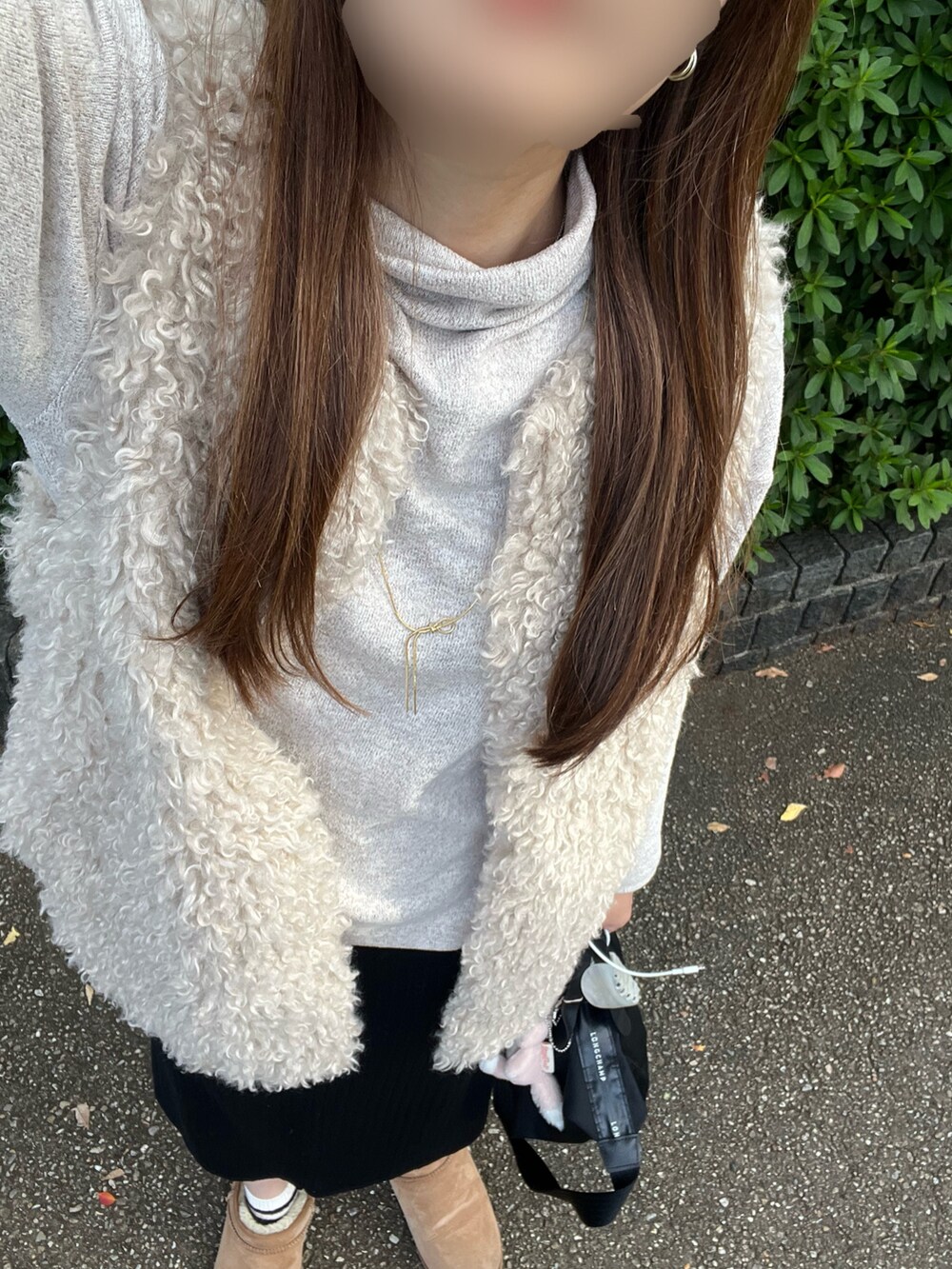 ブラック系のベスト、ホワイト系のトップス、ブラック系のスカートを着用したレディースの秋コーディネートの3枚目の写真