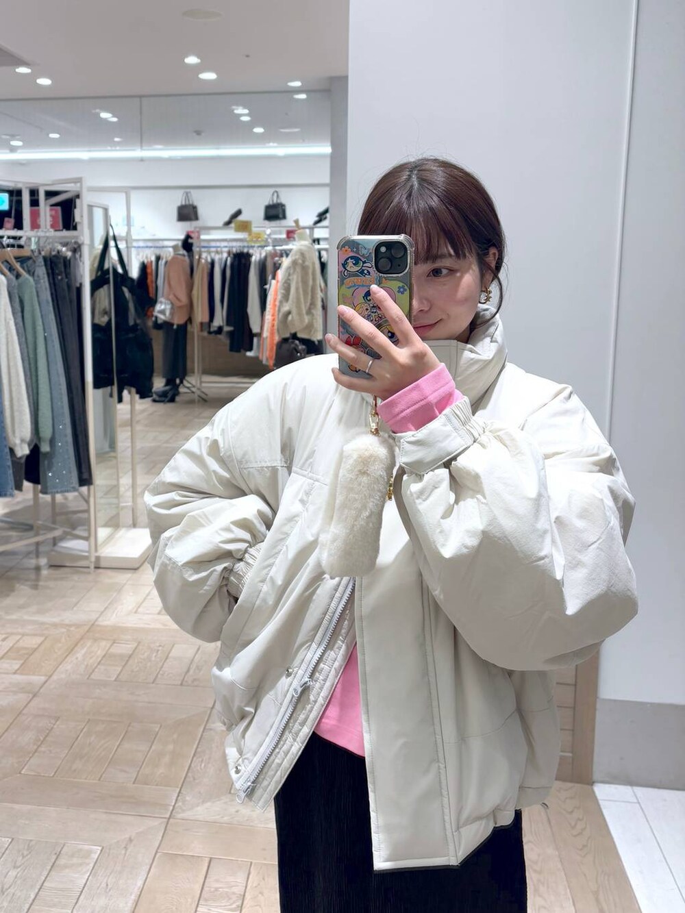 ホワイト系のその他アウター、ブラック系のスカート、シルバー系のショルダーバッグを着用したレディースの冬コーディネートの2枚目の写真