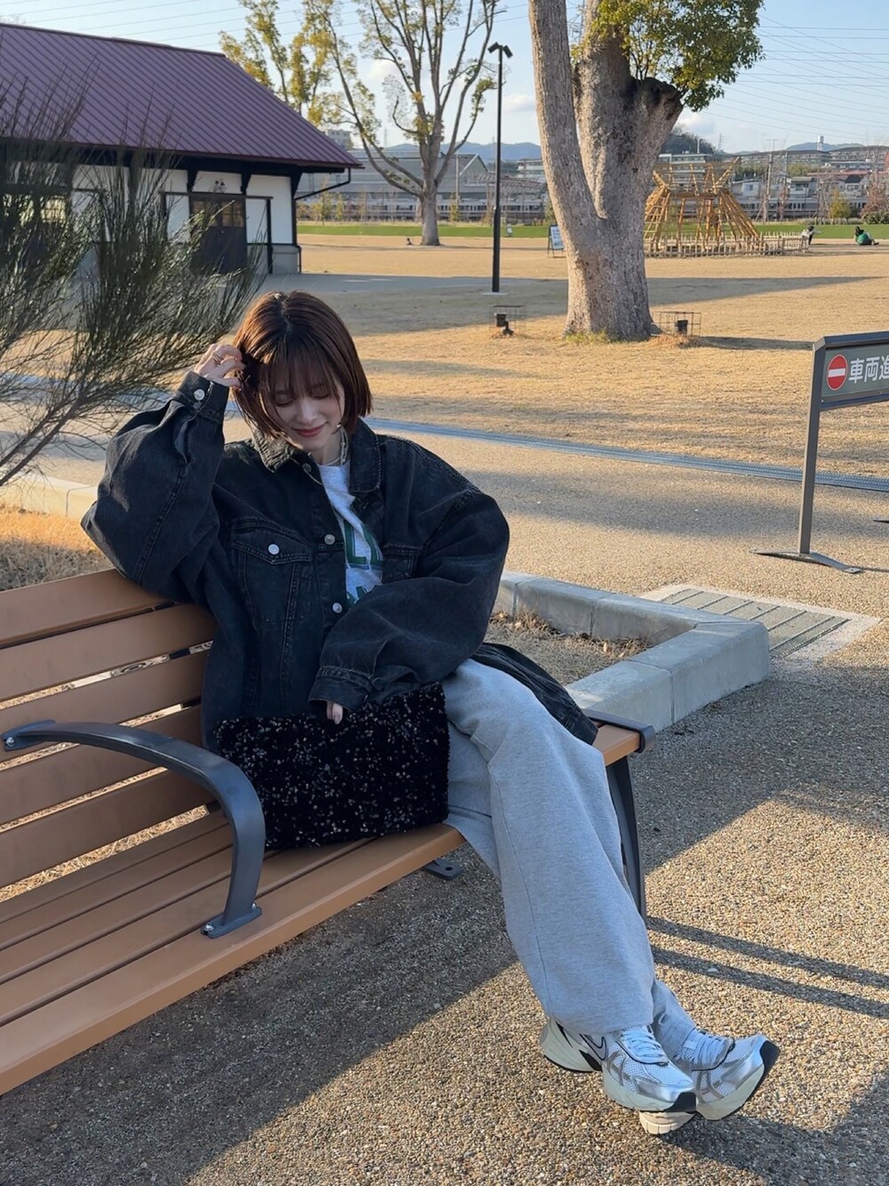 ブラック系のデニムジャケット、ブラック系のトートバッグ、グレー系のスウェットを着用したレディースの春コーディネートの4枚目の写真