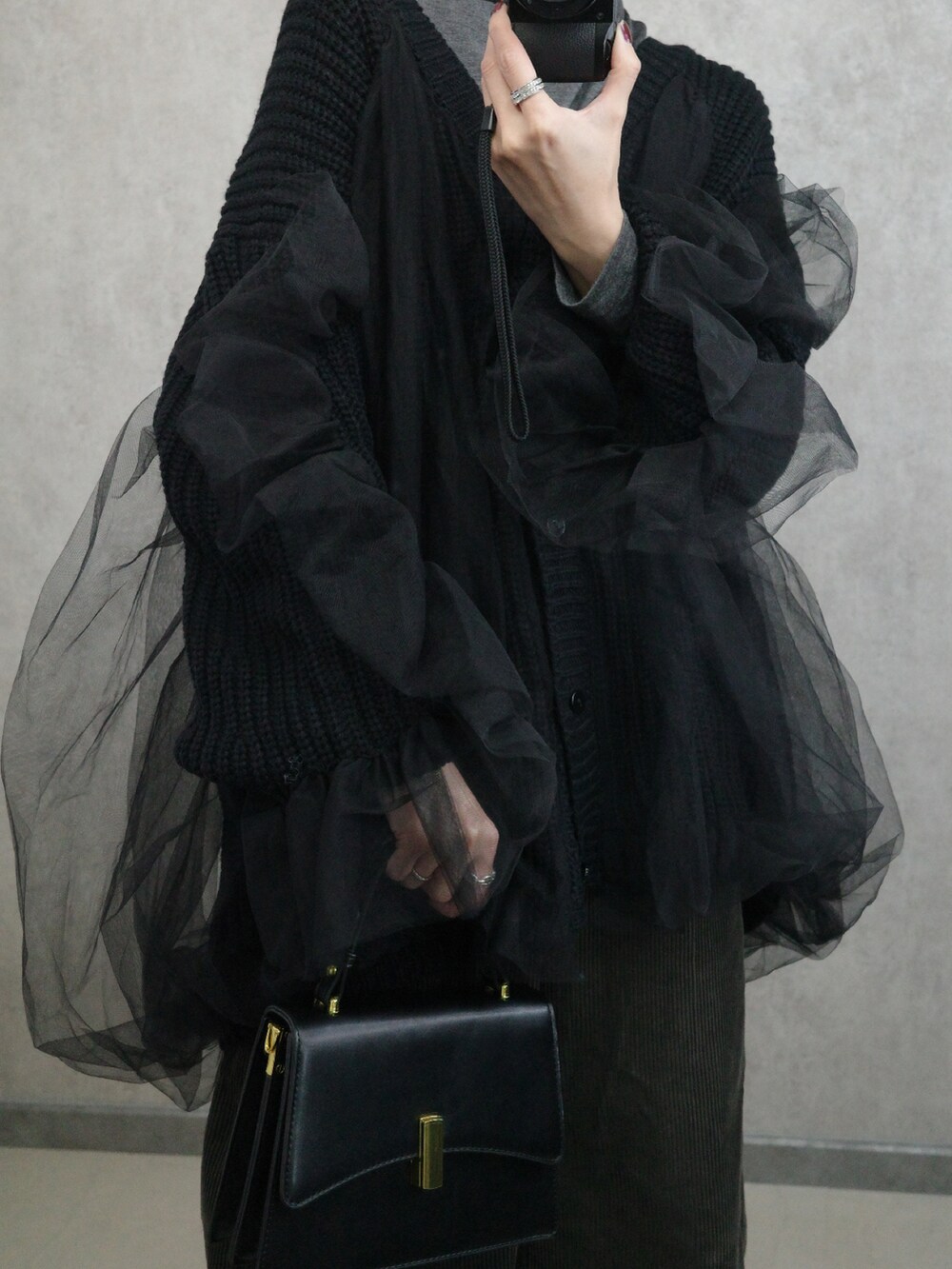 ブラック系のカーディガン/ボレロ、ブラック系のショルダーバッグを着用したレディースの秋コーディネートの2枚目の写真