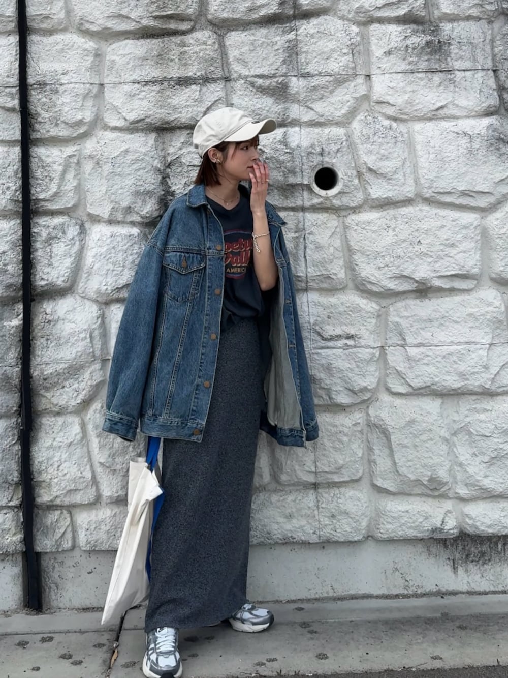 ブルー系のデニムジャケット、グレー系のTシャツ/カットソー、グレー系のスカートを着用したレディースの春コーディネートの2枚目の写真