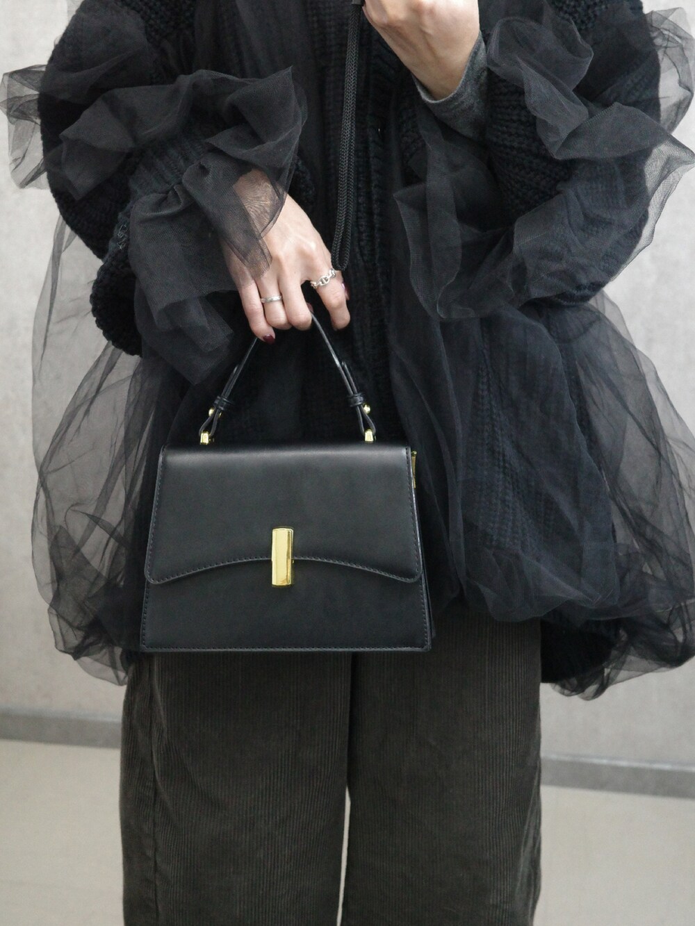 ブラック系のカーディガン/ボレロ、ブラック系のショルダーバッグを着用したレディースの秋コーディネートの4枚目の写真
