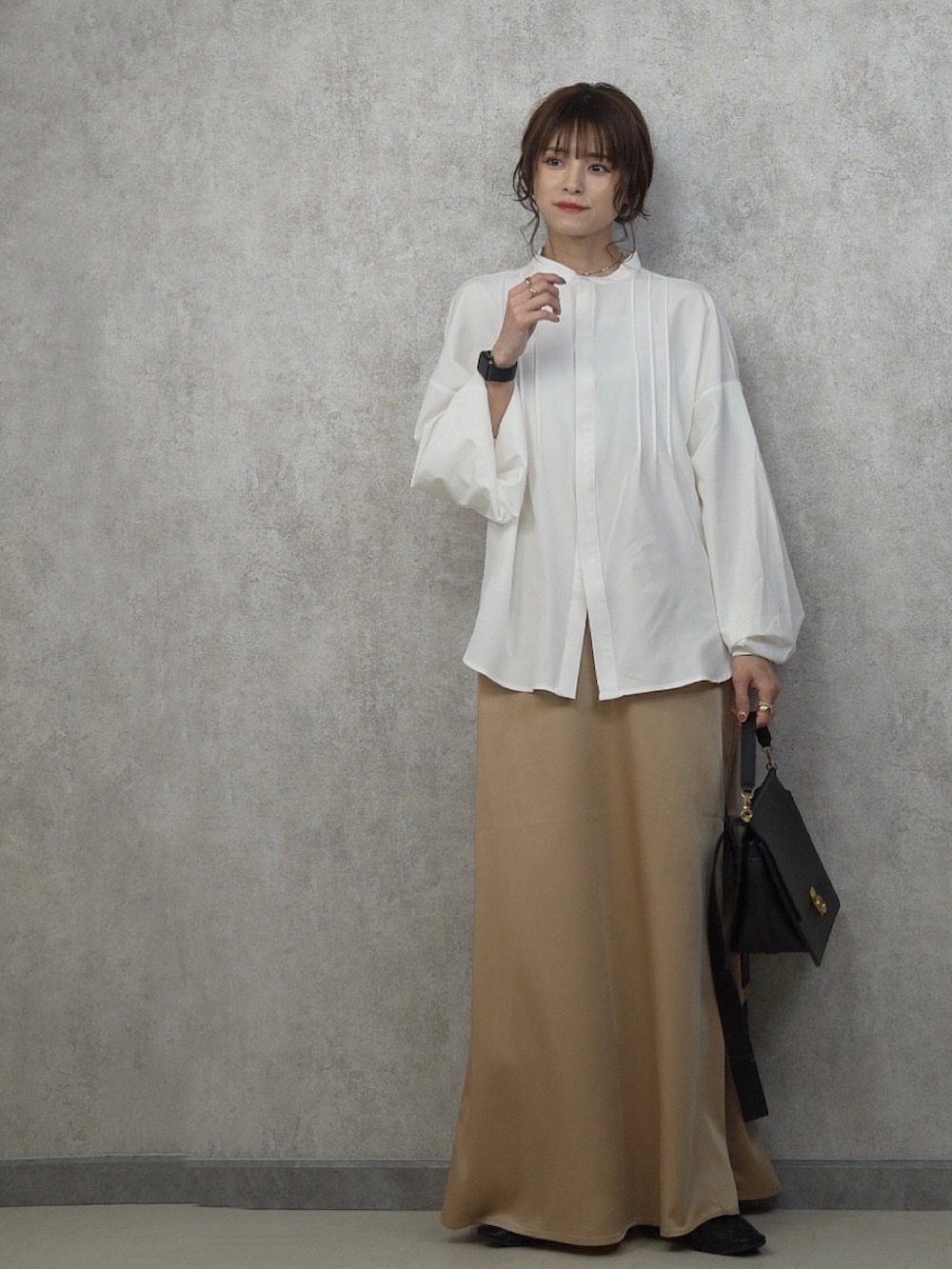 ベージュ系のスカート、ホワイト系のシャツ/ブラウス、ブラック系のローファーを着用したレディースの春コーディネートの2枚目の写真