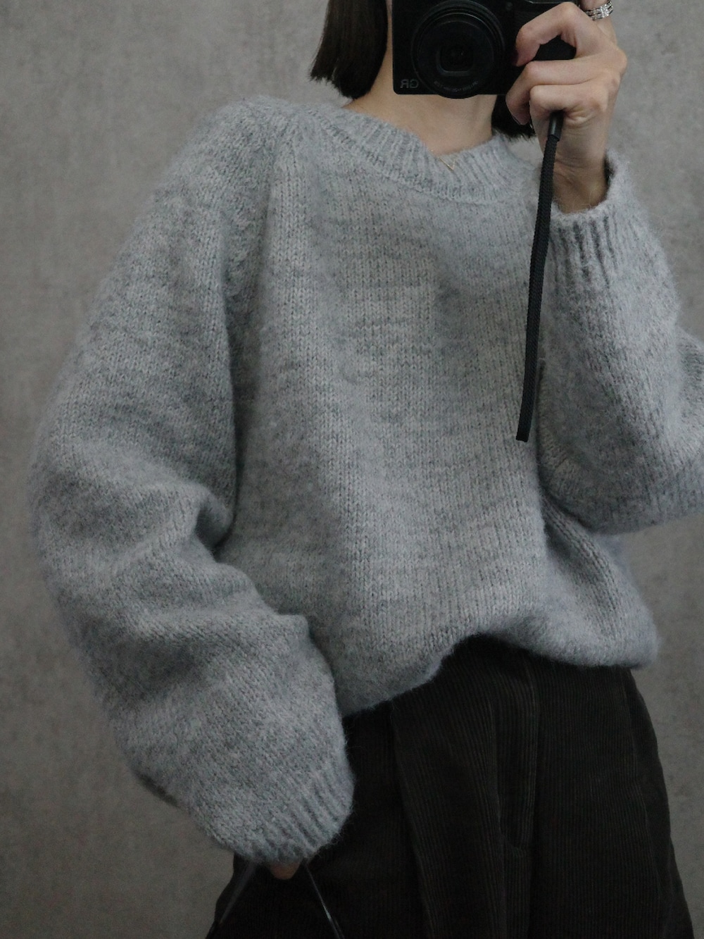 グレー系のニット/セーター、ブラック系のショルダーバッグを着用したレディースの秋コーディネートの4枚目の写真