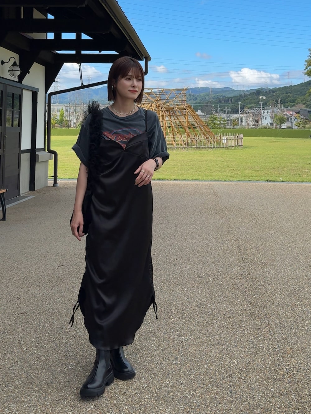 ブラック系のブーツ、ブラック系のショルダーバッグ、ブラック系のワンピースを着用したレディースの夏コーディネートの3枚目の写真