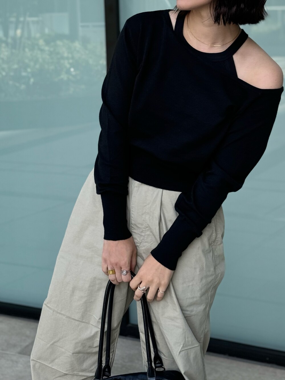 ブラック系のニット/セーター、ブラック系のボストンバッグを着用したレディースの秋コーディネートの4枚目の写真