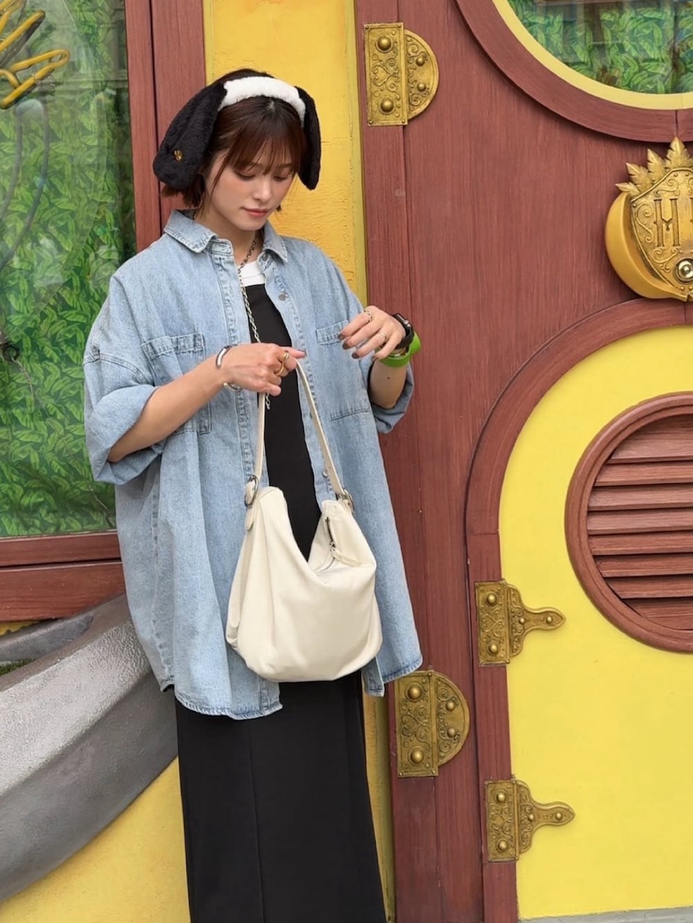 ブルー系のシャツ/ブラウス、ブラック系のワンピース、ホワイト系のバッグを着用したレディースの夏コーディネートの2枚目の写真