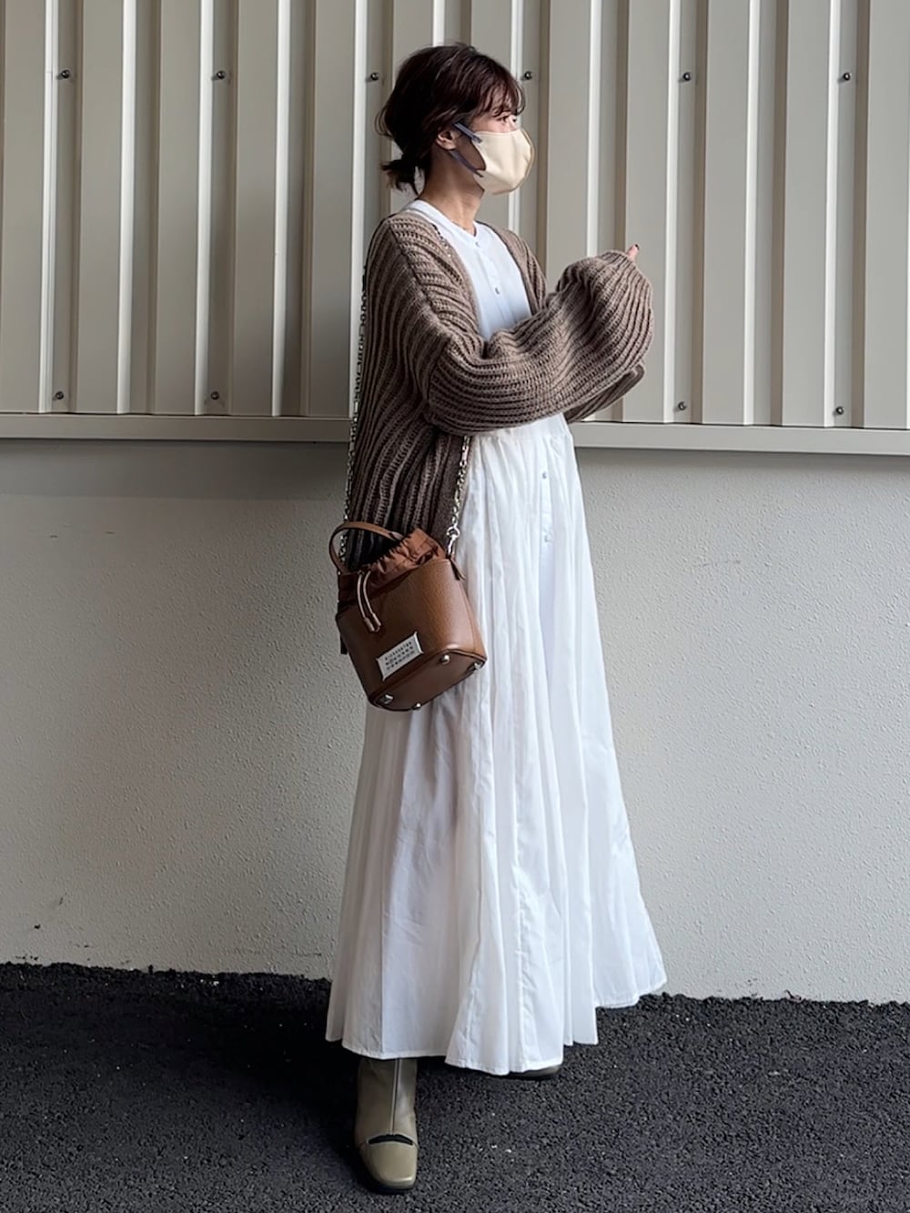 ホワイト系のシャツワンピース、ブラウン系のカーディガン/ボレロを着用したレディースの秋コーディネートの2枚目の写真