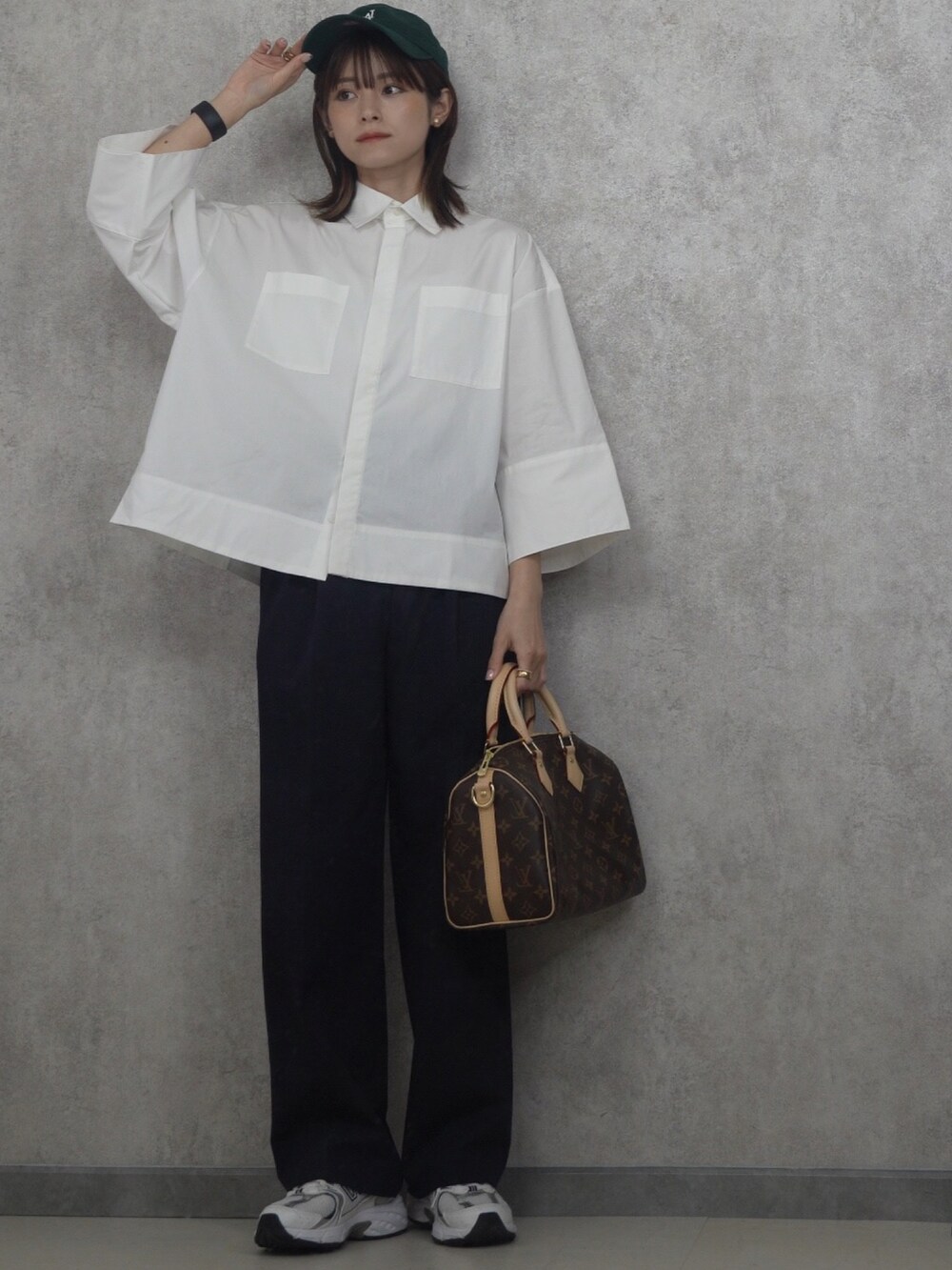 ホワイト系のシャツ/ブラウス、ゴールド系のイヤリング、グリーン系のキャップを着用したレディースの冬コーディネートの3枚目の写真