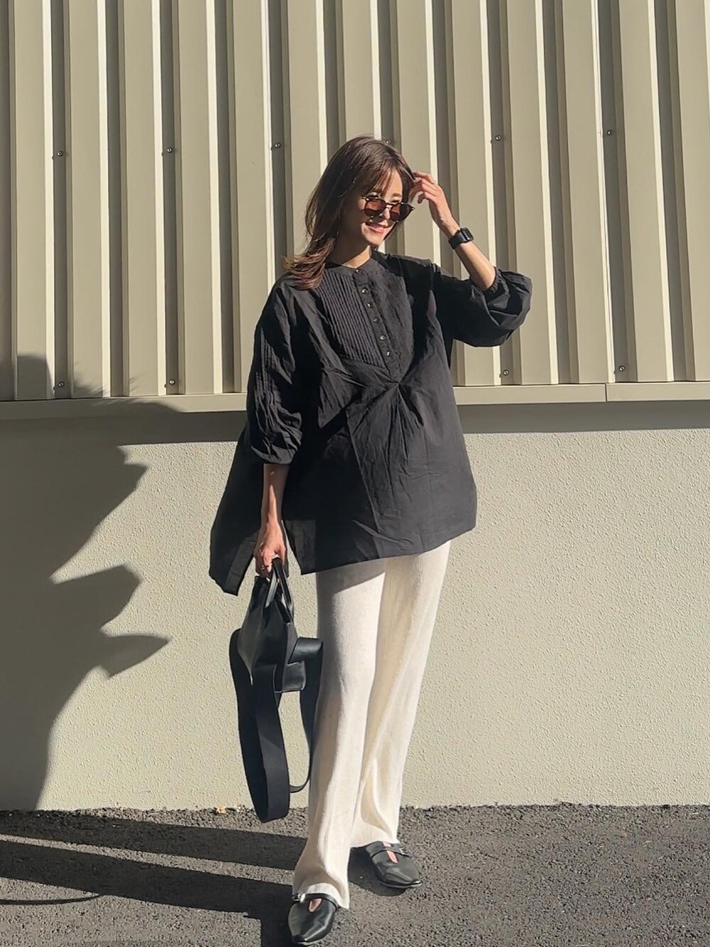 ブラック系のシャツ/ブラウス、ブラック系のパンプスを着用したレディースの秋コーディネートの3枚目の写真