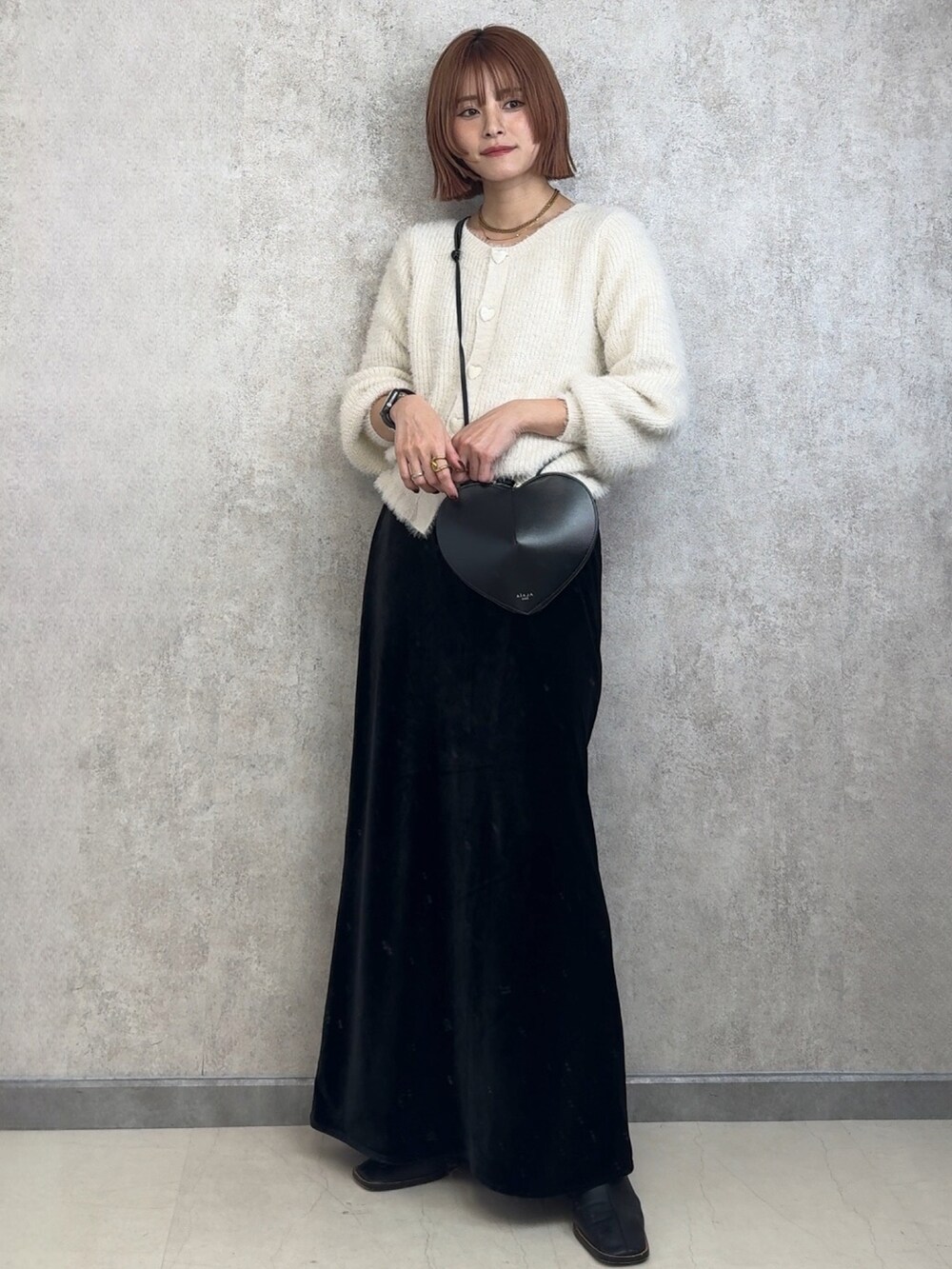 ブラック系のブーツ、ブラック系のスカートを着用したレディースの冬コーディネートの2枚目の写真