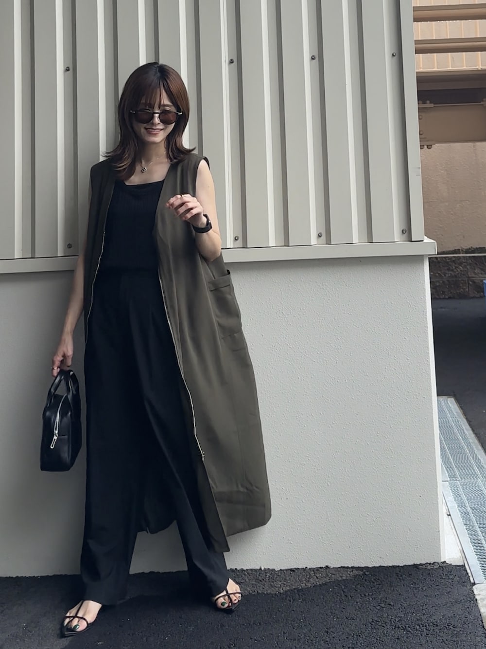 グリーン系のジャンパースカート、ブラック系のTシャツ/カットソー、ブラック系のサンダルを着用したレディースの夏コーディネートの3枚目の写真