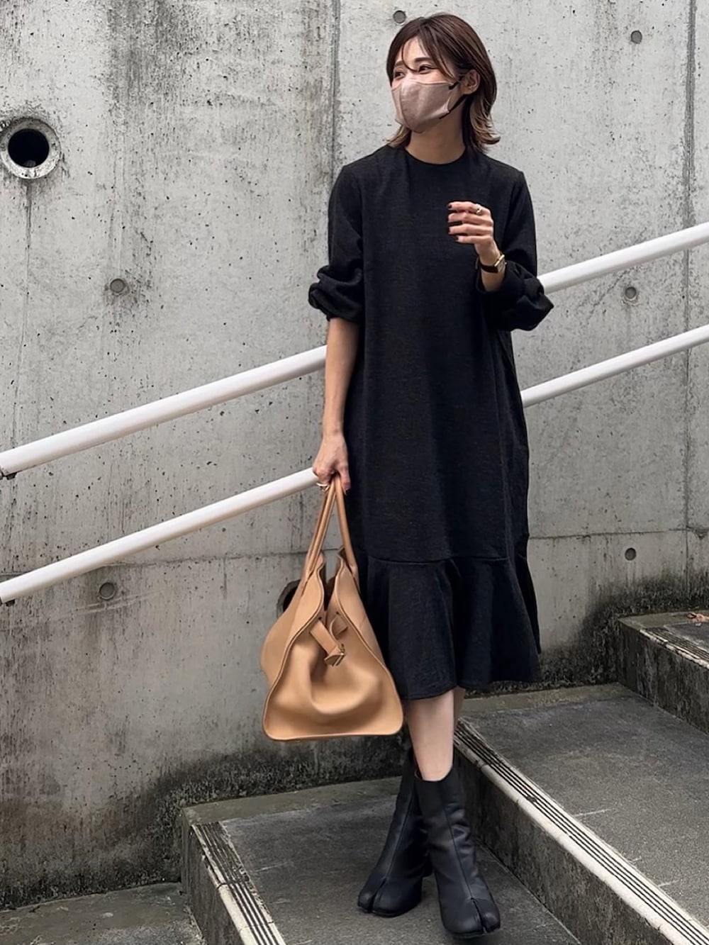 グレー系のワンピース、ブラック系のベストを着用したレディースの秋コーディネートの4枚目の写真