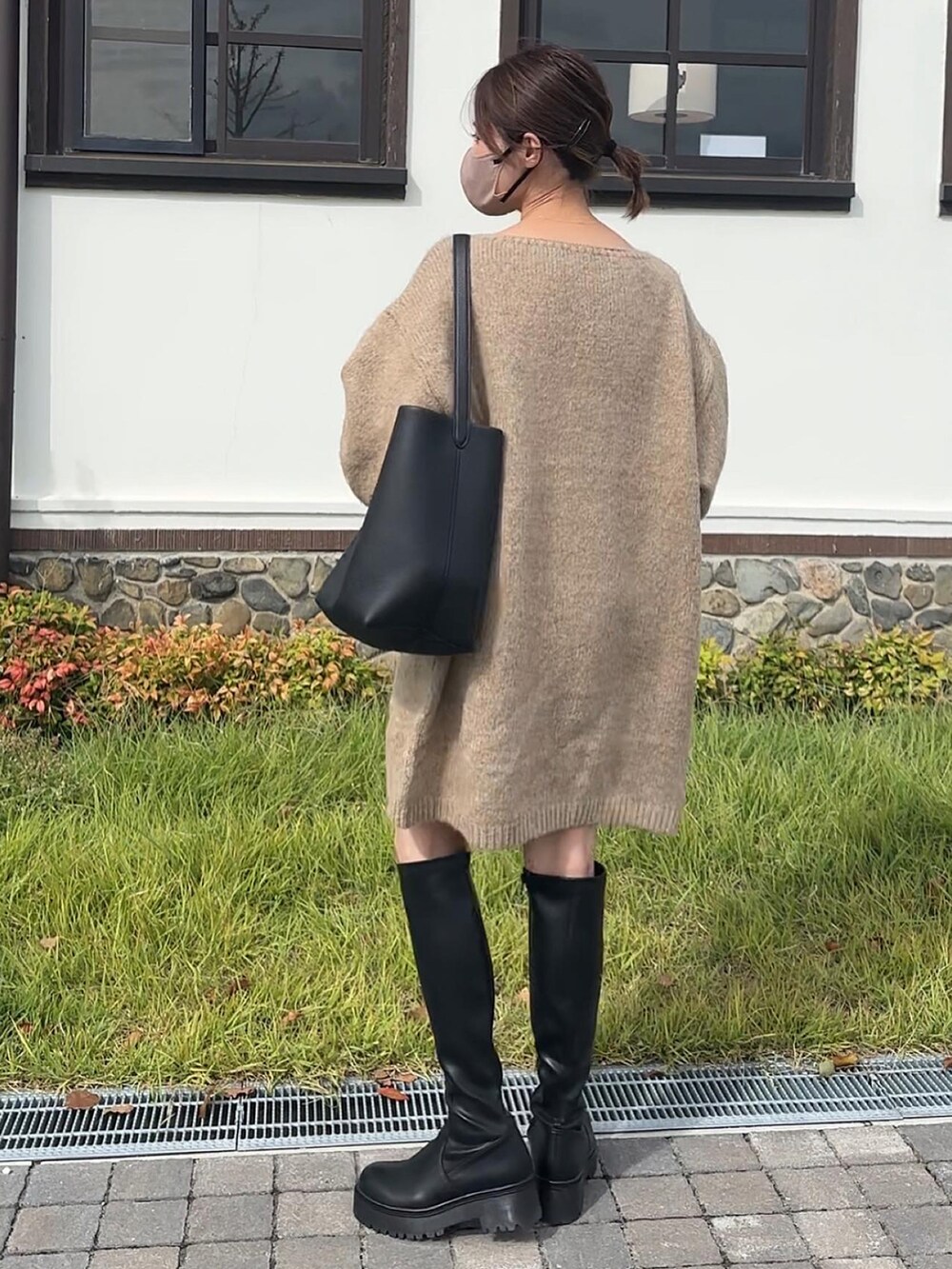 ベージュ系のワンピース、ブラック系のブーツを着用したレディースの秋コーディネートの3枚目の写真