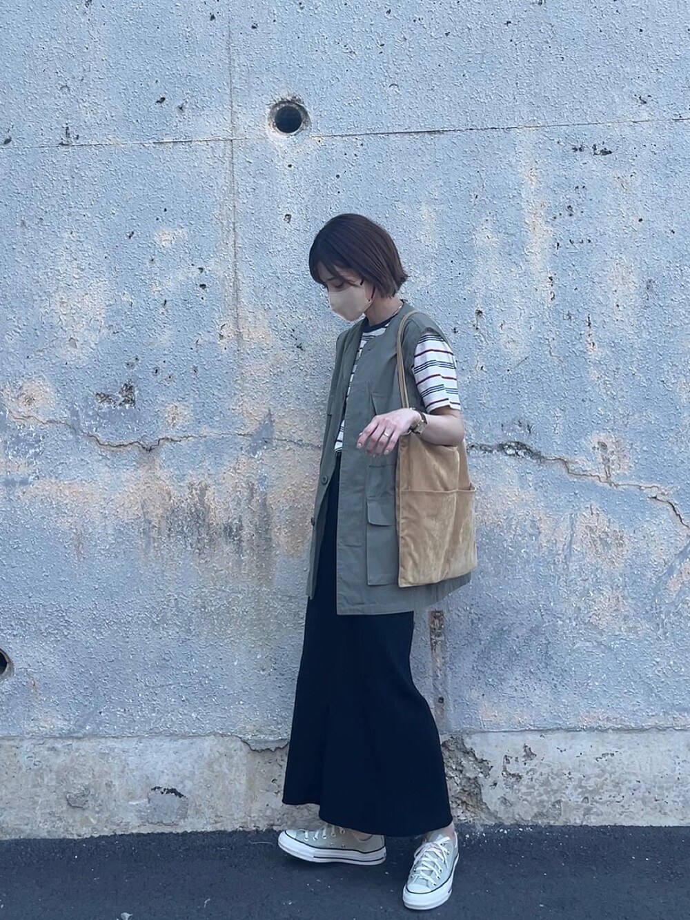 ベージュ系のトップス、ブラック系のスカート、イエロー系のトートバッグを着用したレディースの春コーディネートの4枚目の写真