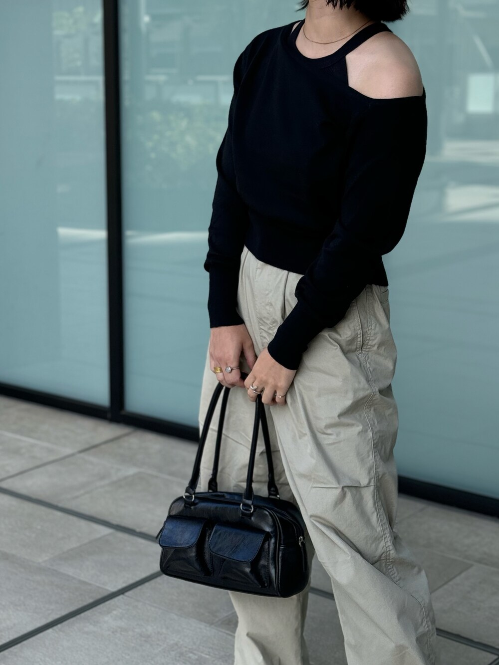 ブラック系のニット/セーター、ブラック系のボストンバッグを着用したレディースの秋コーディネートの3枚目の写真