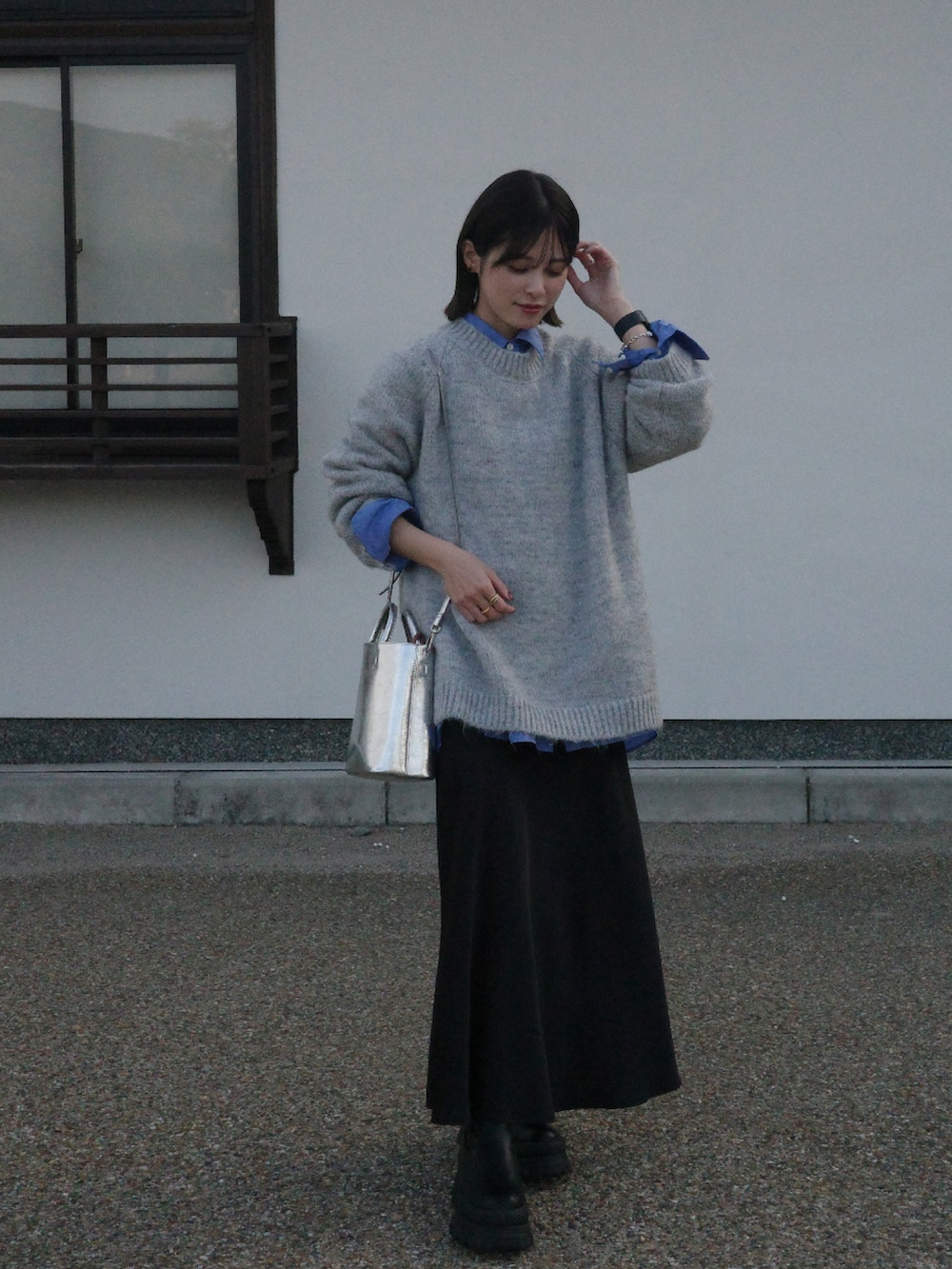 グレー系のニット/セーター、ブラック系のスカートを着用したレディースの秋コーディネートの3枚目の写真