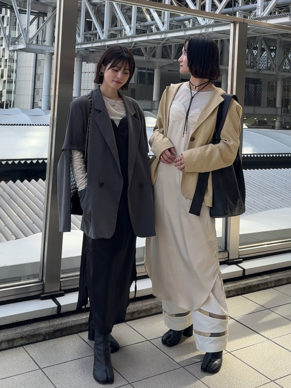 ブラック系のワンピース、ホワイト系のワンピース、グレー系のテーラードジャケットを着用したレディースの秋コーディネートの2枚目の写真