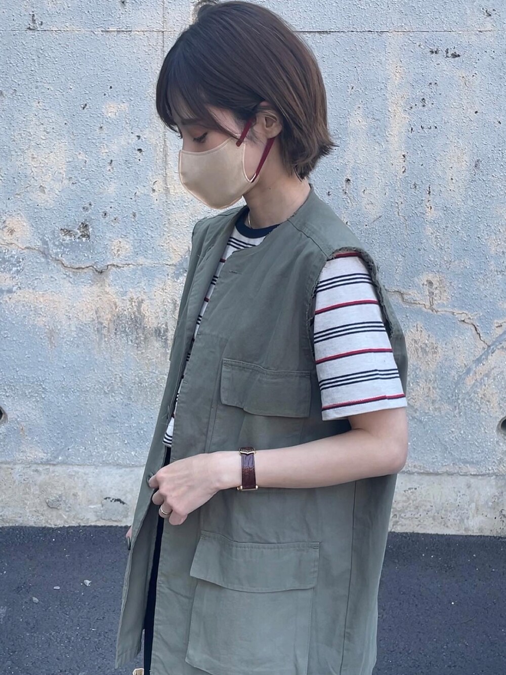 ベージュ系のトップス、ブラック系のスカート、イエロー系のトートバッグを着用したレディースの春コーディネートの5枚目の写真