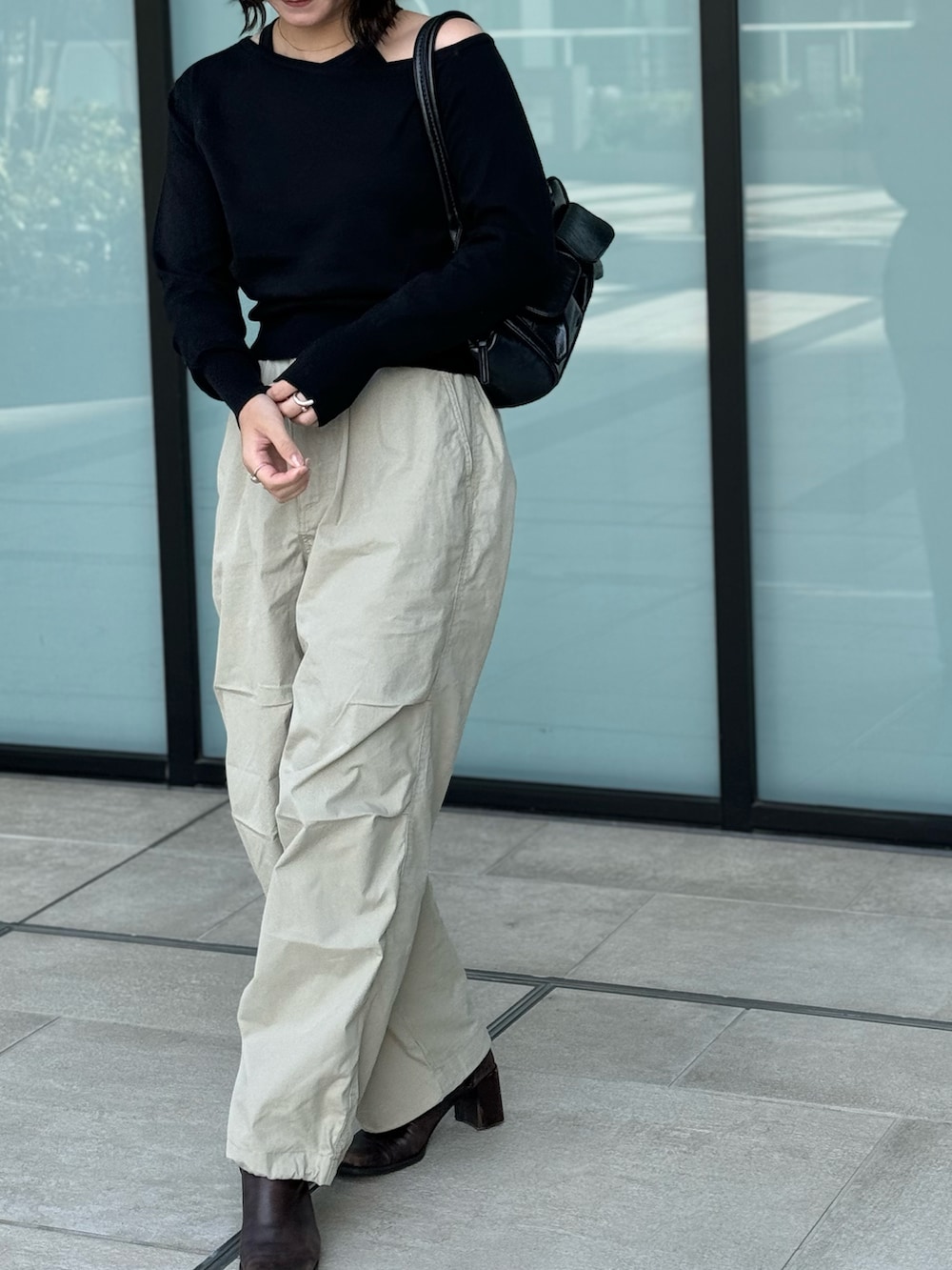 ブラック系のニット/セーター、ブラック系のボストンバッグを着用したレディースの秋コーディネートの2枚目の写真