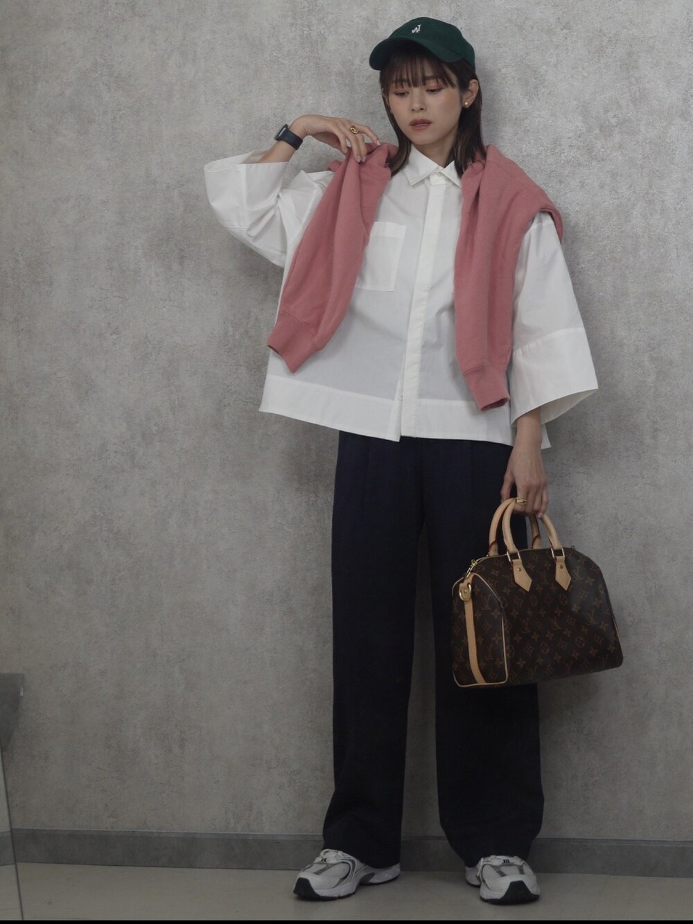 ホワイト系のシャツ/ブラウス、ゴールド系のイヤリング、グリーン系のキャップを着用したレディースの冬コーディネートの2枚目の写真