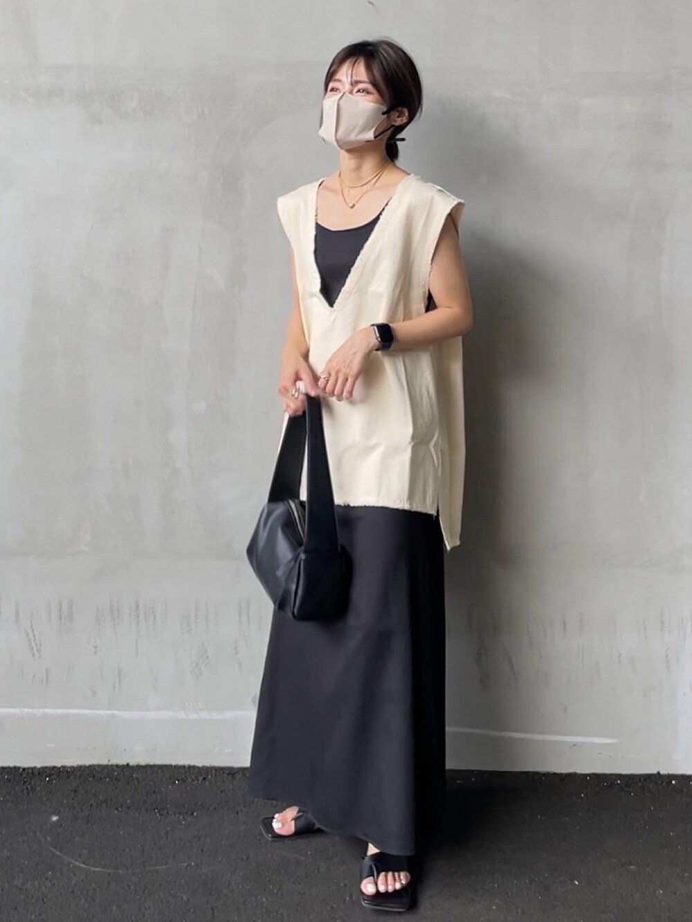 ホワイト系のベスト、ブラック系のサンダル、ホワイト系のワンピースを着用したレディースの夏コーディネートの2枚目の写真