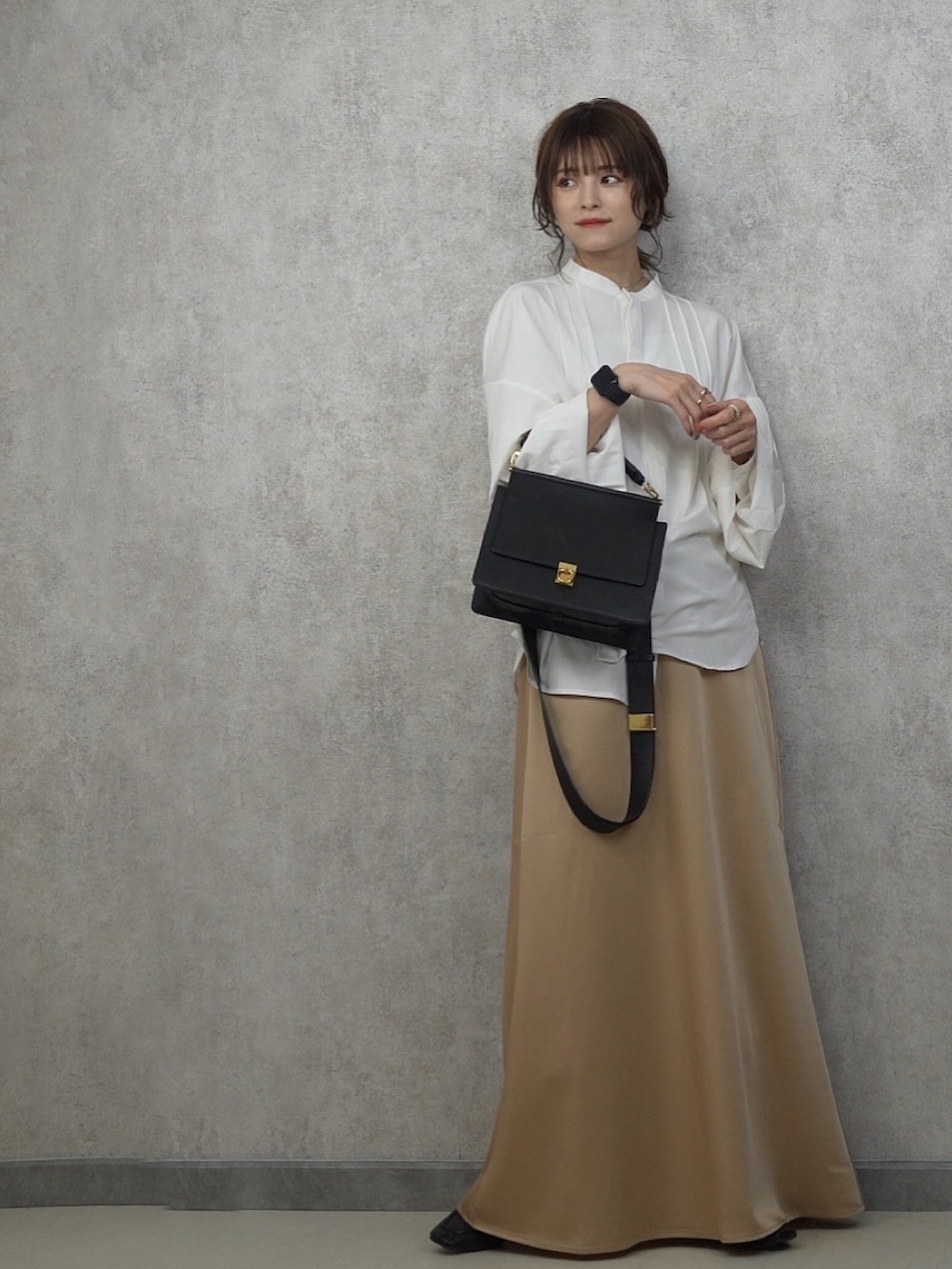 ベージュ系のスカート、ホワイト系のシャツ/ブラウス、ブラック系のローファーを着用したレディースの春コーディネートの3枚目の写真