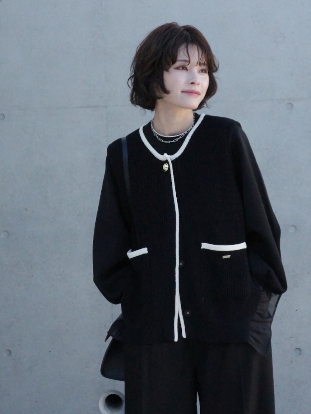 ブラック系のベストを着用したレディースの冬コーディネートの2枚目の写真