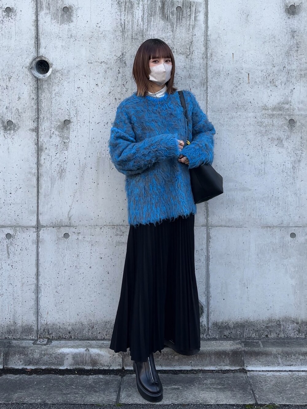 ブルー系のニット/セーター、ブラック系のワンピース/ドレスを着用したレディースの冬コーディネートの2枚目の写真