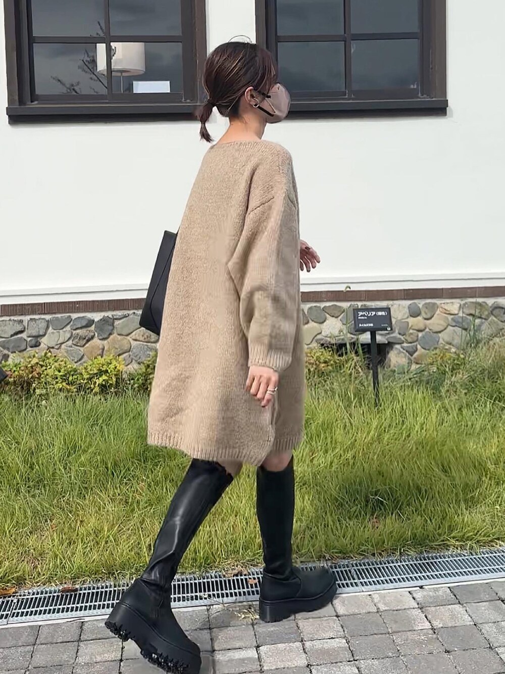 ベージュ系のワンピース、ブラック系のブーツを着用したレディースの秋コーディネートの4枚目の写真